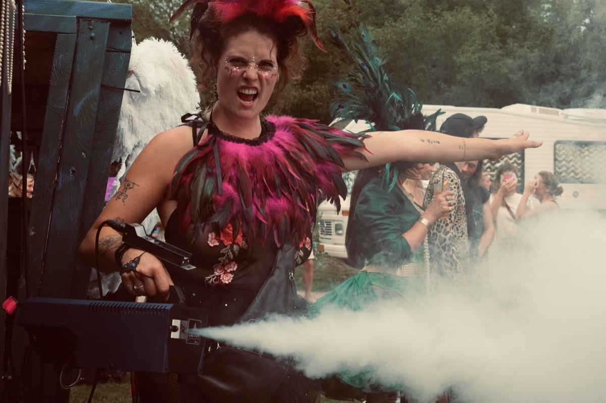 Chiara in verenkraag vuurt een rookmachine af tijdens een festivaloptreden